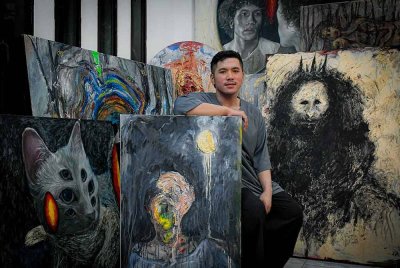 Pelukis Aiman Zamri, 29, bergambar bersama hasil seni lukis berunsurkan surealisme ketika ditemui di kediamannya di Bandar Puteri Klang, baru-baru ini.
