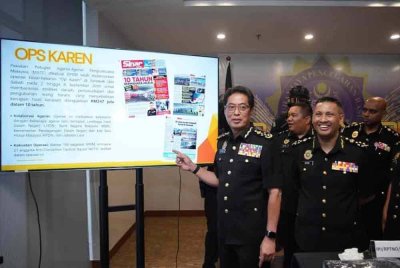 Azam (kiri) menunjukkan pelaporan Sinar Harian berhubung isu penyelewengan diesel di Sarawak.