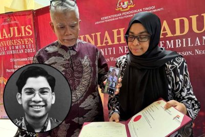 Muhamad Rizal bersama isteri melihat sijil diterima arwah anaknya.