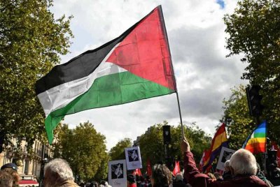 Seorang penunjuk perasaan mengibarkan bendera Palestin semasa menyertai perarakan yang menuntut pengiktirafan negara Palestin dan penghentian pembunuhan beramai-ramai di Paris pada 21 September 2025. Foto AFP