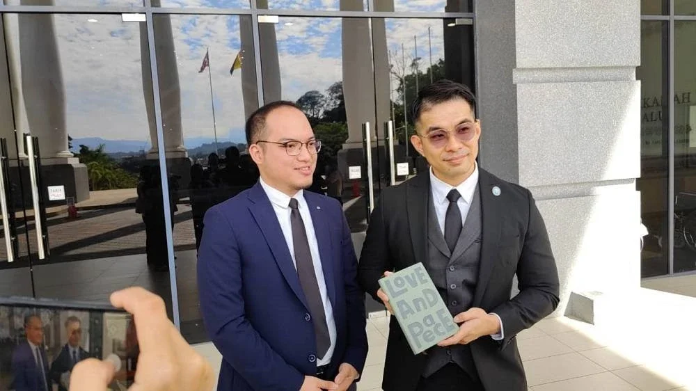 Mohd Syarulnizam menunjukkan buku 'love and peace' sebagai replika dalam inkues kematian Zara Qairina di Mahkamah Koroner.