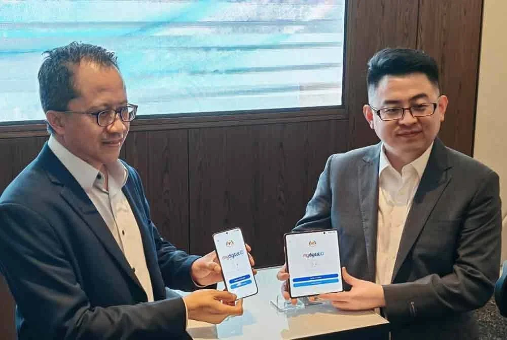 Justin (kanan) dan Nik Hisham (kiri) menunjukkan paparan aplikasi MyDigital ID pada telefon pintar HONOR selepas majlis menandatangani MoU antara MyDigital ID Sdn Bhd dan HONOR Malaysia pada Rabu.