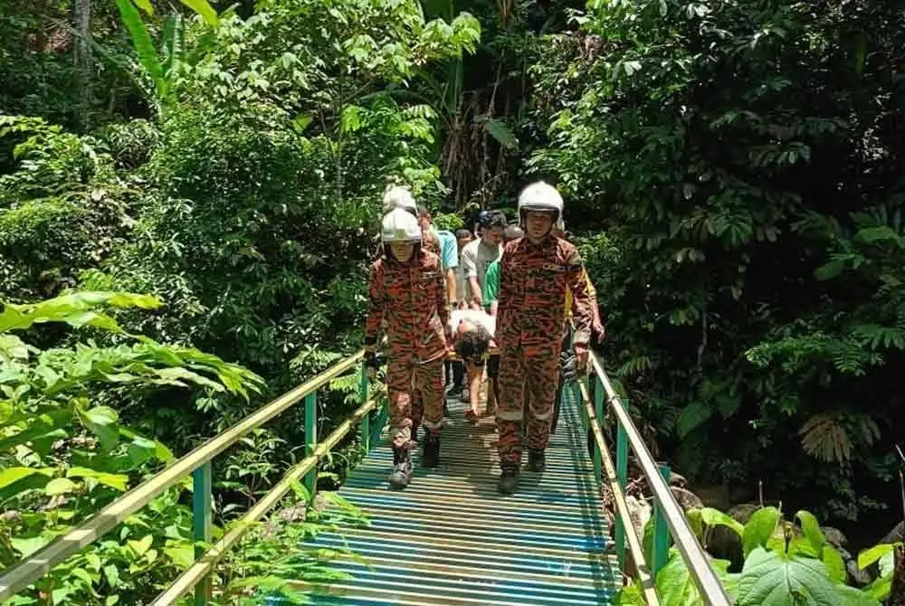 Pasukan bomba memberikan rawatan awal sebelum membawa mangsa turun menggunakan pengusung.