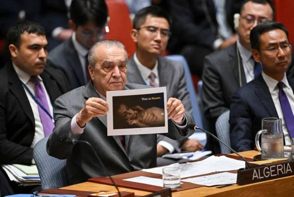 Duta Algeria ke PBB Amar Bendjama mengangkat gambar kanak-kanak kebuluran di Gaza semasa mesyuarat Majlis Keselamatan PBB di New York pada 5 Ogos 2025. Foto AFP