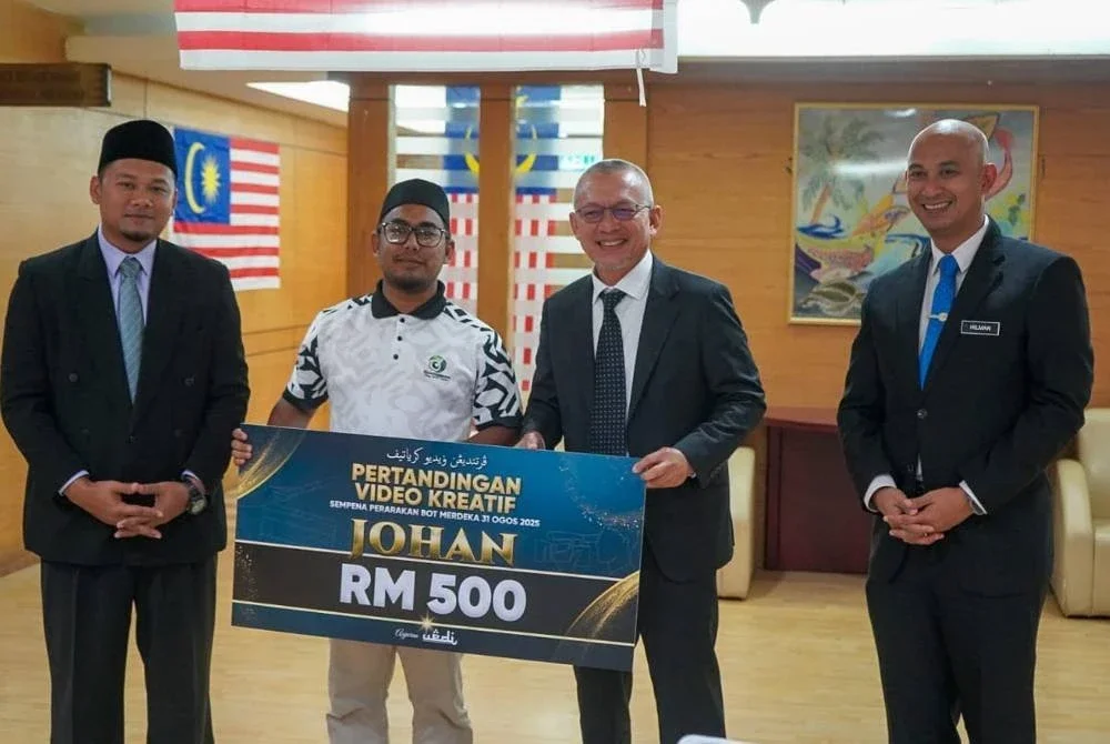 Razali (dua dari kanan) menyampaikan hadiah kepada pemenang Pertandingan Video Kreatif sempena Program Perarakan Bot Merdeka di Wisma Darul Iman, Kuala Terengganu.