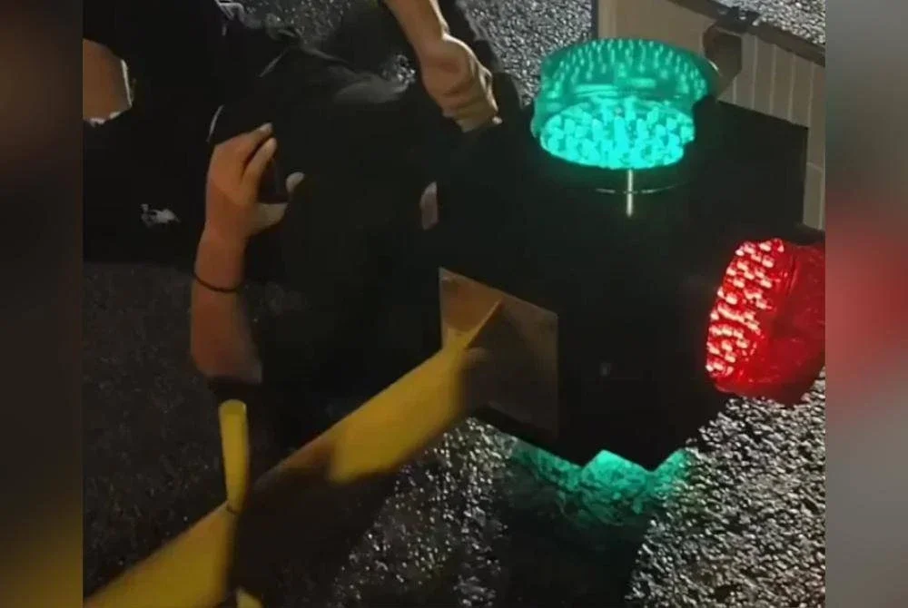 Seorang lelaki menjadi tular selepas kepalanya tersangkut hampir sejam dalam sebuah lampu isyarat. Foto Agensi