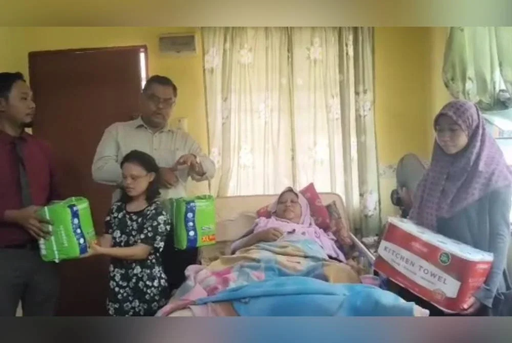 Nur Amalina (kanan) setia menjaga ibu dan adiknya di rumah mereka di Kampung Tanjung Langsat.