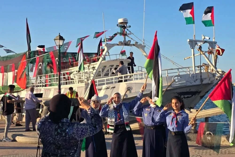 Pengakap perempuan Libya bergambar di hadapan kapal Omar al-Mukhtar di Tripoli. AFP 