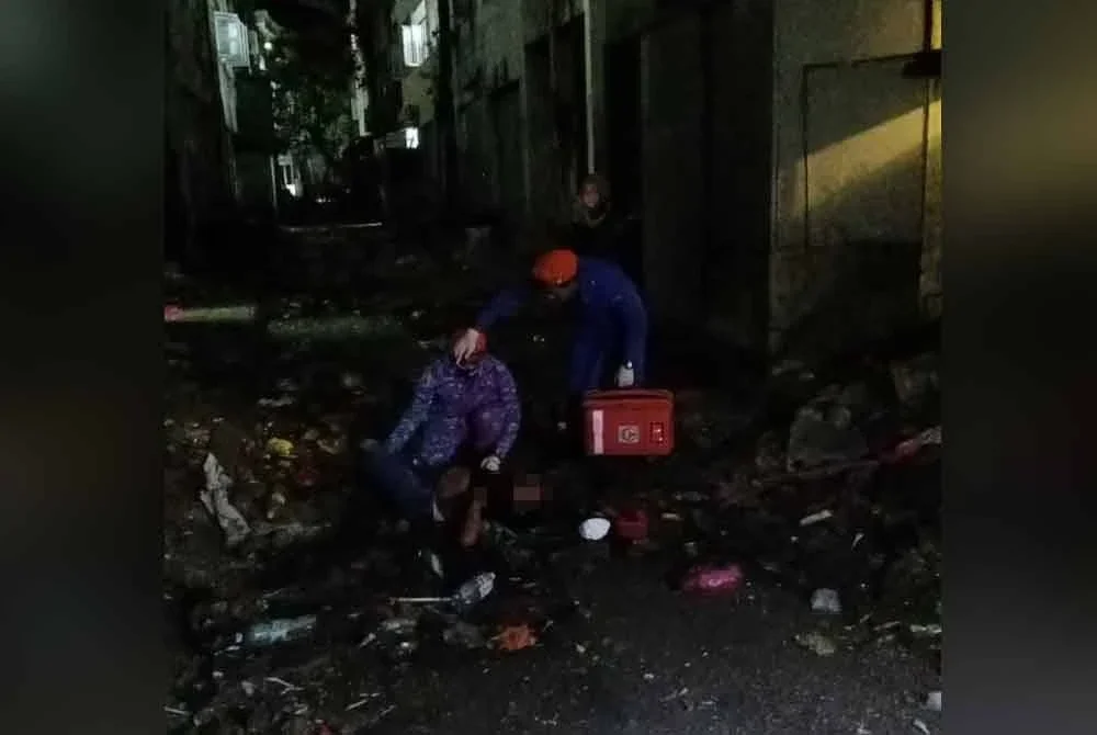 Anggota APM memberikan rawatan kepada seorang wanita warga asing yang cedera setelah terjun dari tingkat tiga bangunan rumah kedai.