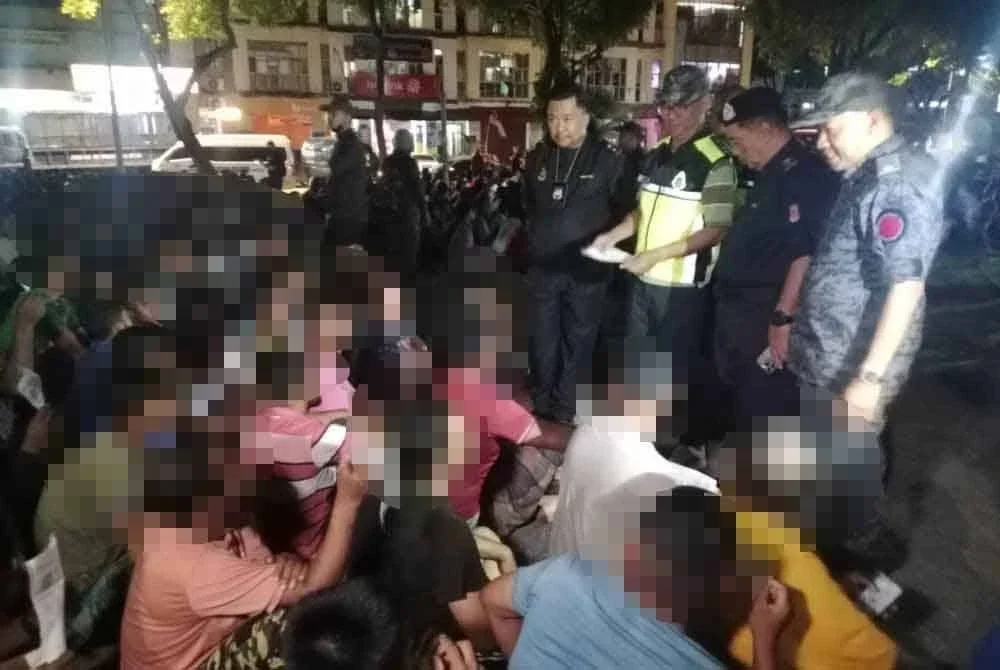Khairul Aminus (tiga dari kanan) memeriksa dokumen warga asing yang ditahan dalam operasi bersepadu yang dijalankan.
