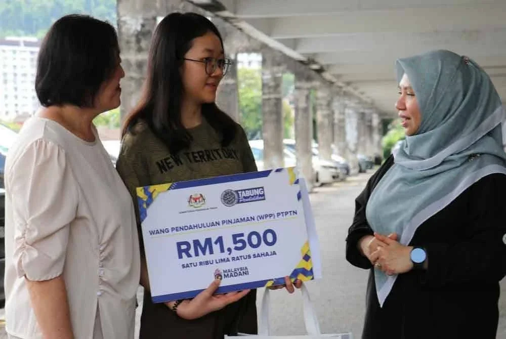 Norliza (kanan) turun padang menyantuni pelajar yang menerima WPP semasa sesi ziarah rumah pelajar di kawasan Bukit Gelugor, Pulau Pinang.