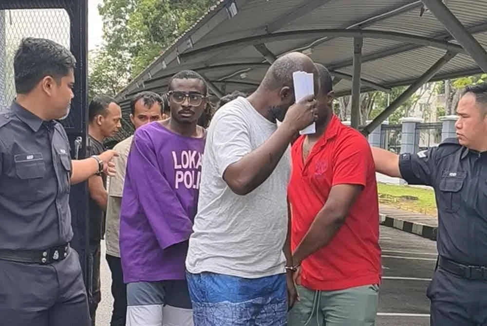 (Dari kiri) Udoh, Eric dan Hendry dibawa polis ke Mahkamah Majistret Seremban pada Khamis.