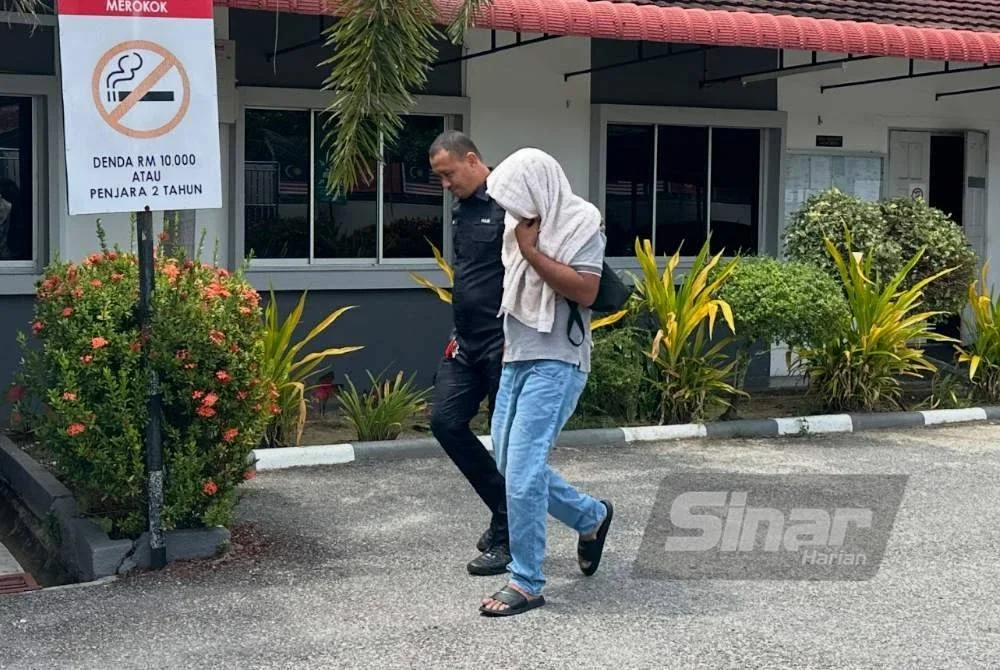 Mohammad Khairuddin (kanan) dikawal polis ketika keluar dari lokap mahkamah. Foto Sinar Harian ADILA SHARINNI WAHID