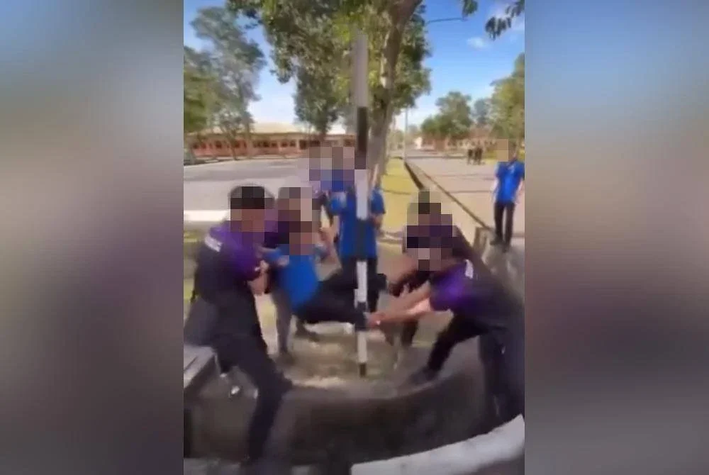 Video yang memaparkan lima pelajar memegang kaki dan tangan seorang pelajar lain dan dengan sengaja ‘menghayunkan’ bahagian kelangkangnya ke arah tiang sebuah papan tanda.