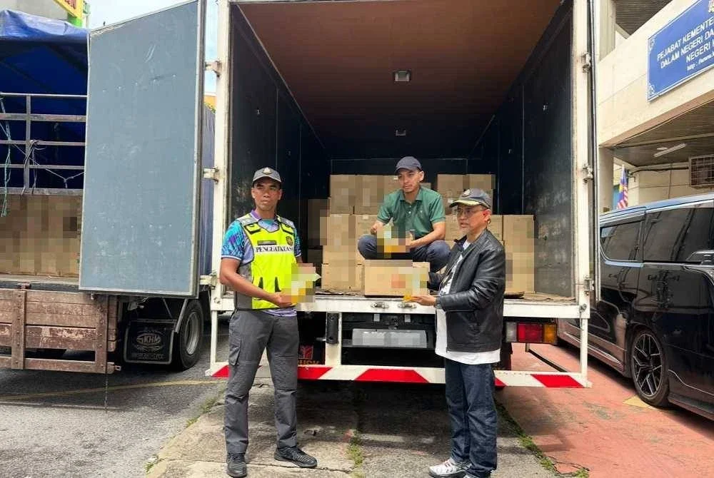 Azman (kanan) memeriksa minyak masak ditemukan dalam dua lori yang telah dirampas. FOTO SINAR HARIAN - ADILA SHARINNI WAHID