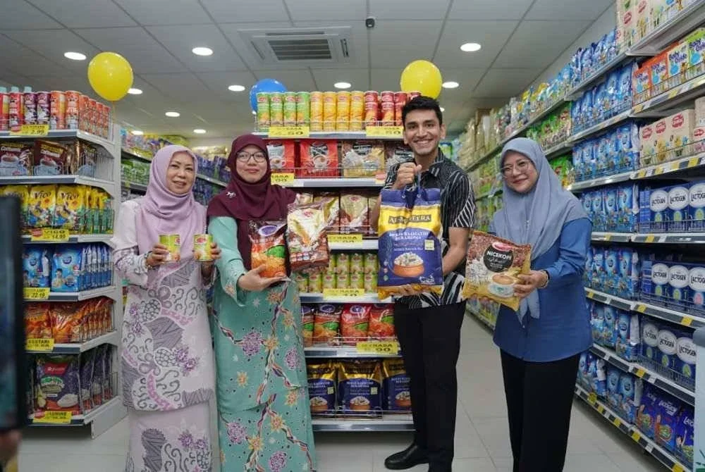 Shaakir (dua dari kanan) dan Anfaal (dua dari kiri) menunjukkan antara barangan yang dijual sempena Majlis Perasmian Pembukaan Mydin Mart Olak Lempit, pada Jumaat.