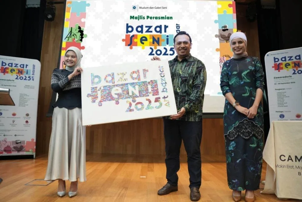Noreen (kiri) menyerahkan cenderamata kepada Ketua Pegawai Perkhidmatan Bank Negara Malaysia, Mohd Fuad Arshad yang hadir merasmikan Bazar Seni 2025.