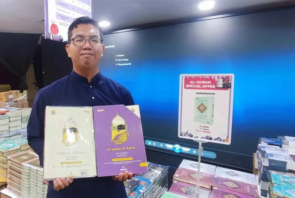 Muhamad Asyraf menunjukkan produk terbaharu Karya Bestari, al-Quran At-Tilawah Perjuzuk yang direka khas untuk membantu umat Islam khatam al-Quran dalam tempoh sebulan.
