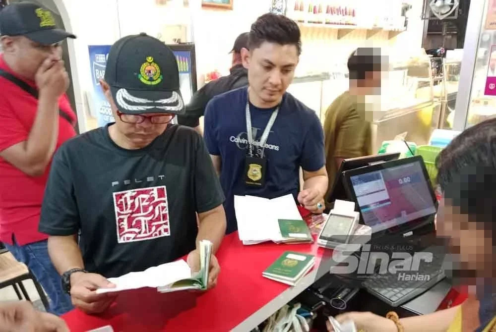 Wan Mohammed Saupee (dua, kiri) menjalankan pemeriksaan terhadap beberapa premis.