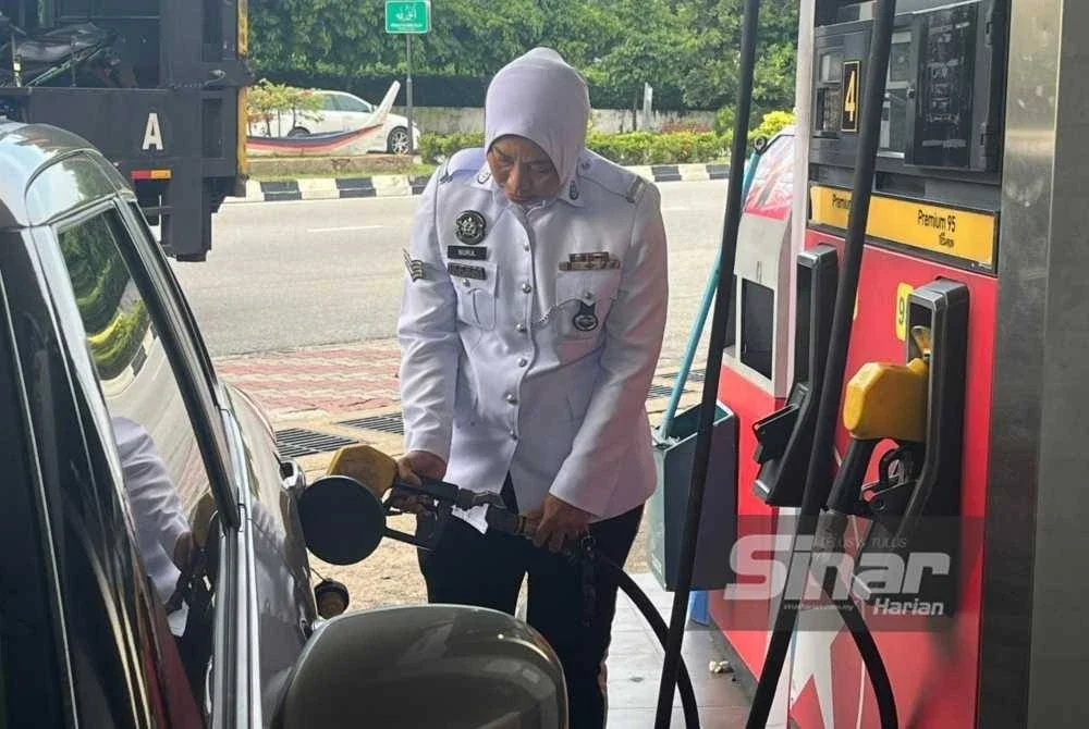 Nur Mariam mengisi minyak di sebuah stesen minyak di pusat bandar Kuala Terengganu pada hari pertama pelaksanaan subsidi petrol Budi Madani RON95.