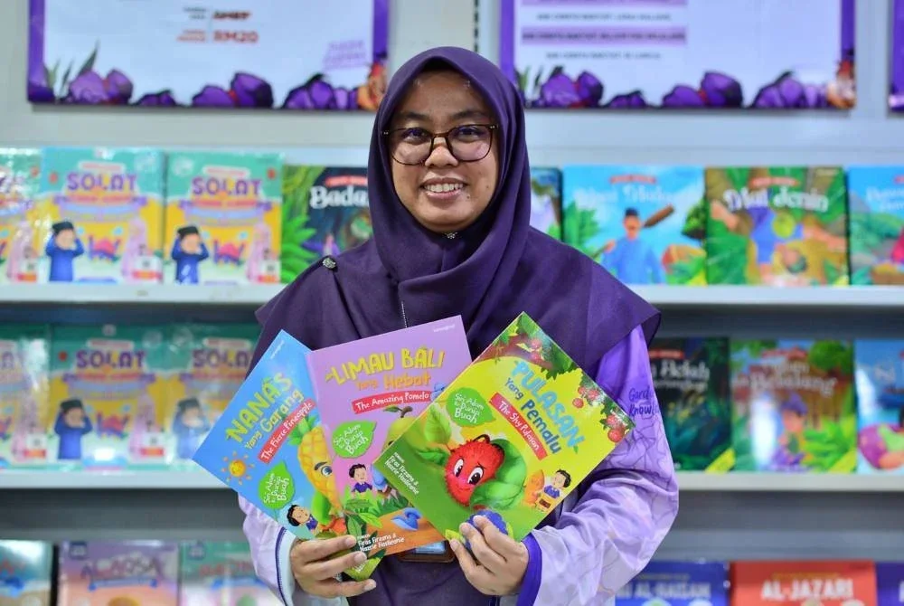 Ismawannie Ismail menunjukkan buku kanak-kanak pelbagai siri di Jualan Gudang Karangkraf.