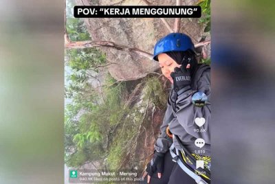 Nur Shafira Aini menerima panggilan telefon ketika mendaki Gunung Nenek Semukut, Kampung Mukut,Pulau Tioman.