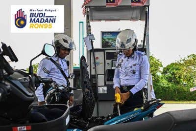 Jurugambar Trafik Ibu Pejabat Daerah (IPD) Seremban, Azrin Abd Aziz (kanan) mengisi petrol RON95 di stesen Petronas S2 City Park pada harga RM1.99 seliter menerusi inisiatif BUDI95 yang bermula pada Sabtu.