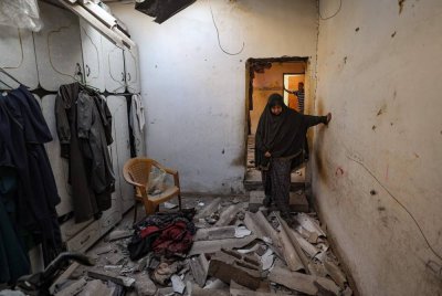 Seorang wanita Palestin berjalan atas runtuhan di dalam sebuah rumah yang terkena serangan udara Israel di Kem Pelarian Nuseirat, Gaza Tengah. Foto AFP