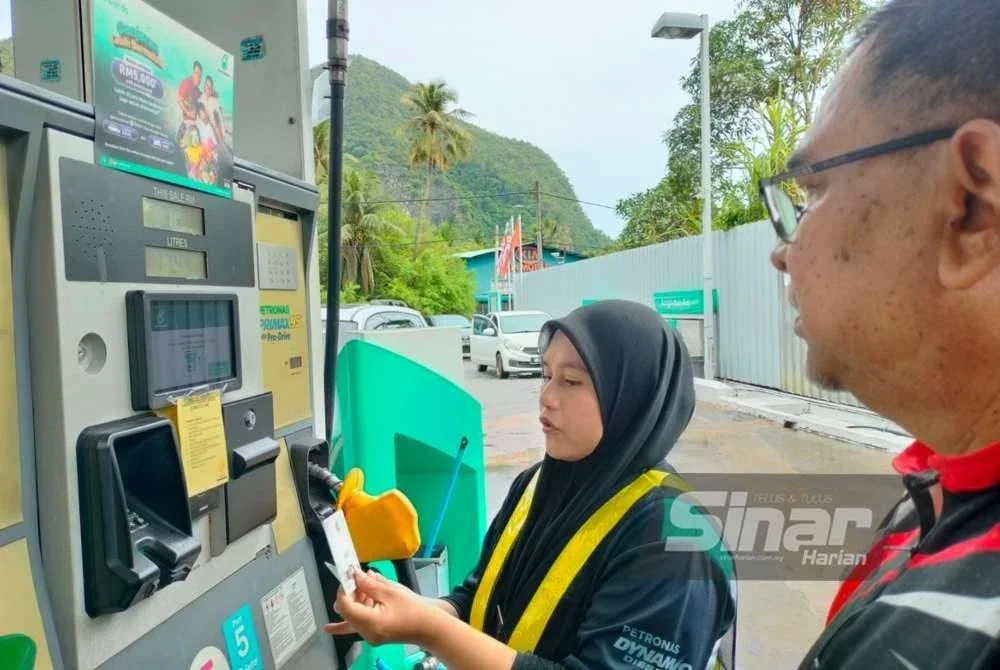 Kakitangan stesen minyak Petronas Baling membantu pelanggan membuat semakan kelayakan BUDI95.