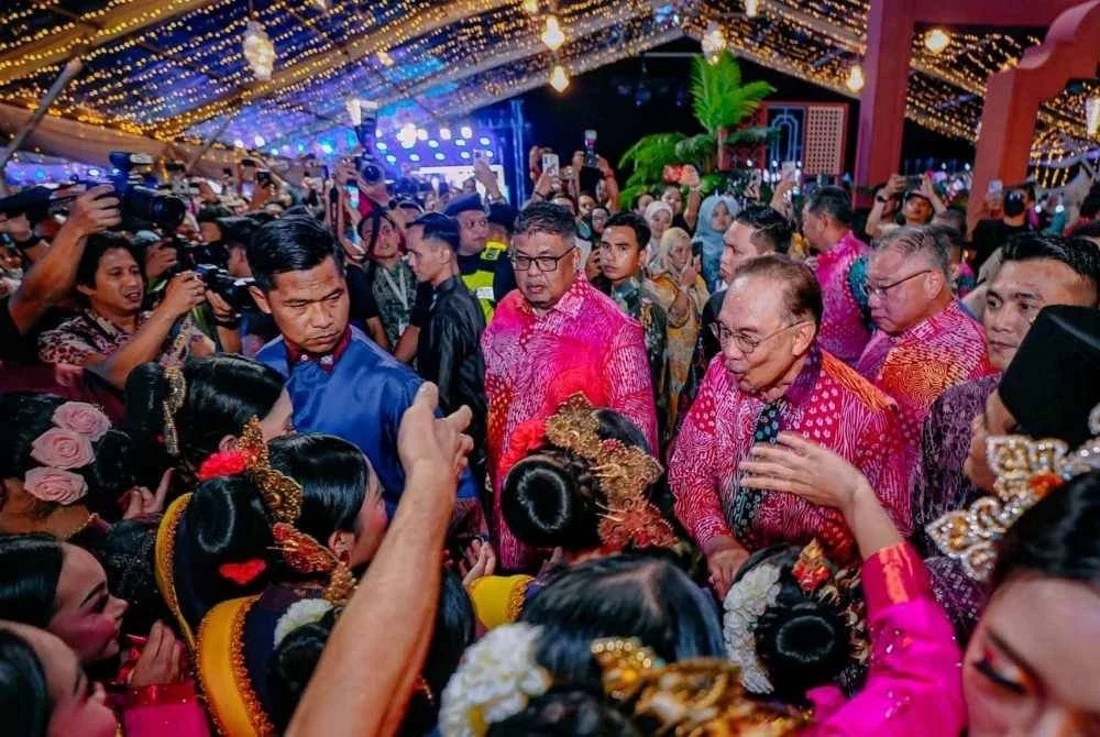 Anwar dan Ab Rauf beramah mesra dengan peserta persembahan sempena Peluncuran Tahun Melawat Malaysia 2026 di Klebang pada Sabtu.