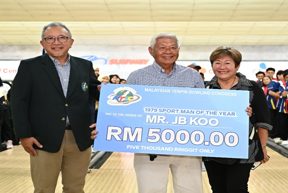 Mohammed Najeeb (kiri) selepas menyerahkan replika cek kepada JB Koo yang turut ditemani isterinya, Doris Koo.