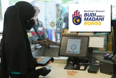 Pekerja Petronas Subang Bestari sedang memeriksa kelayakan pelanggannya yang layak menerima inisiatif BUDI95 pada Ahad. FFoto Sinar Harian MOHD HALIM ABDUL WAHID