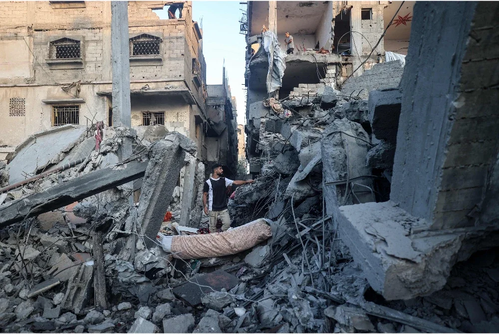 Seorang lelaki Palestin berdiri di tengah-tengah runtuhan bangunan yang musnah akibat serangan Israel, di kem pelarian Nuseirat di tengah Semenanjung Gaza. Foto AFP