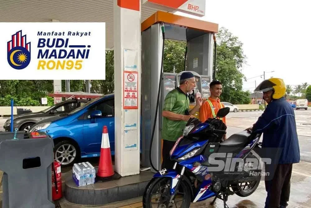 Ahmad (kiri) membantu pekerjanya melayani pelanggan bagi memastikan semuanya berjalan lancar sempena hari pertama pelaksanaan sistem BUDI95 melibatkan pengguna biasa. Foto: SINAR HARIAN/HAZELEN LIANA KAMARUDIN