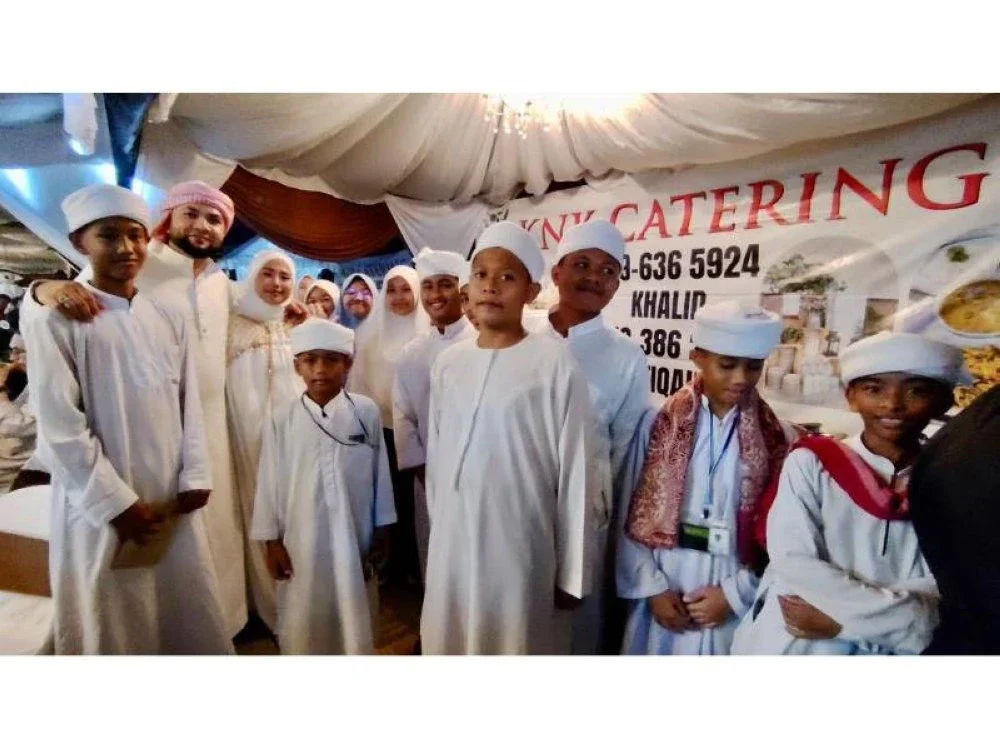 Mohamad Salim (dua, kiri) gembira dapat beramah mesra dengan para pelajar sekolah tahfiz.