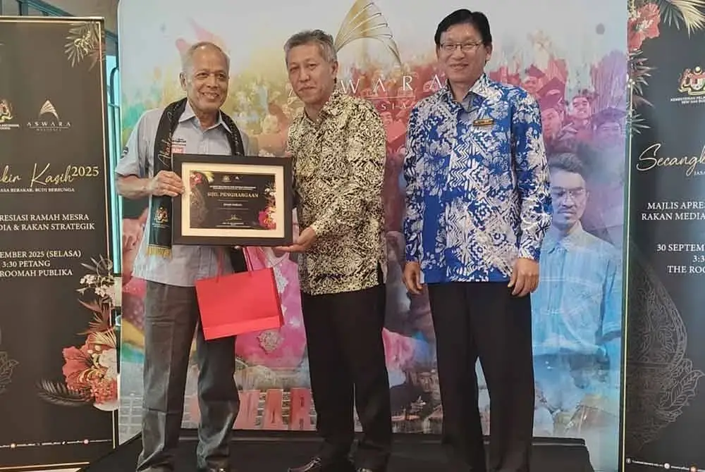 Shaharudrin (tengah) diiringi Tan menyerahkan penghargaan kepada Penasihat Bersama Kumpulan Karangkraf, Datuk Muhammad Nasir Hamzah (kiri)