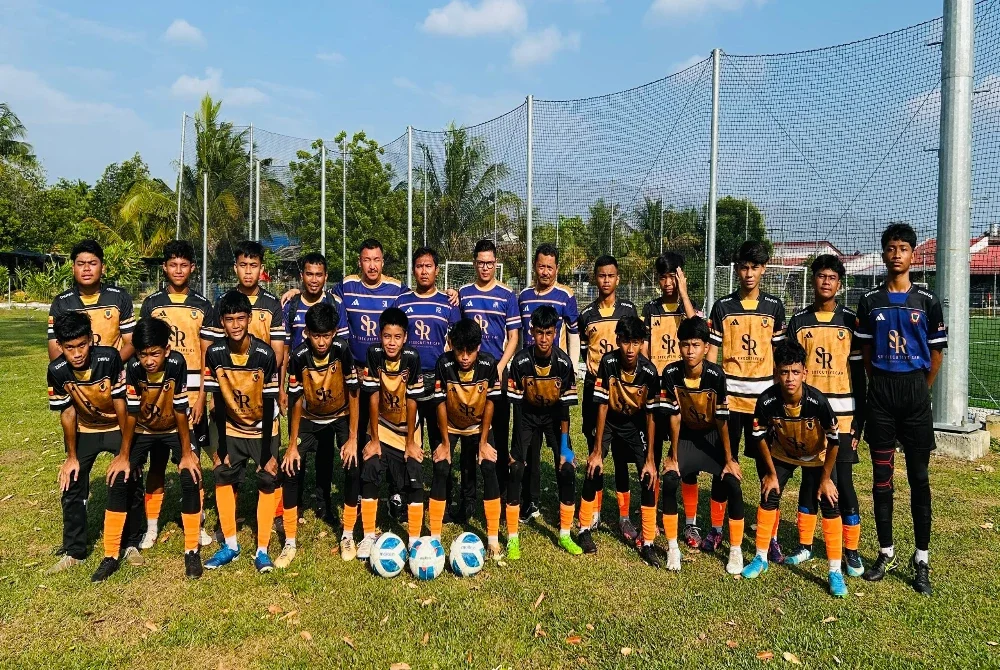 Muhamad Hasrulnizam (barisan belakang, tujuh dari kiri) bersama pemain dan barisan kejurulatihan SMK Hillcrest.