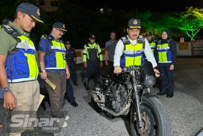 Muhammad Kifli (tengah) melihat motosikal yang disita kerana tiada cukai jalan dalam Operasi Khas Gempur JPJ di Akademi JPJ Wilayah Timur, di Kota Bharu pada Isnin. 