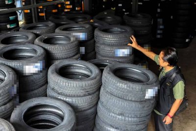 Anggota Bahagian Operasi Khas (BOK) SPRM memeriksa tayar yang disimpan di dalam kontena di sebuah premis menerusi operasi bersepadu, Ops Grip, hari ini. Foto Bernama