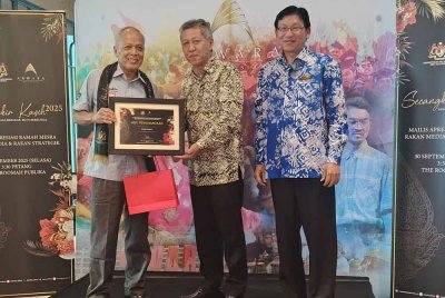 Shaharudrin (tengah) diiringi Tan menyerahkan penghargaan kepada Penasihat Bersama Kumpulan Karangkraf, Datuk Muhammad Nasir Hamzah (kiri)