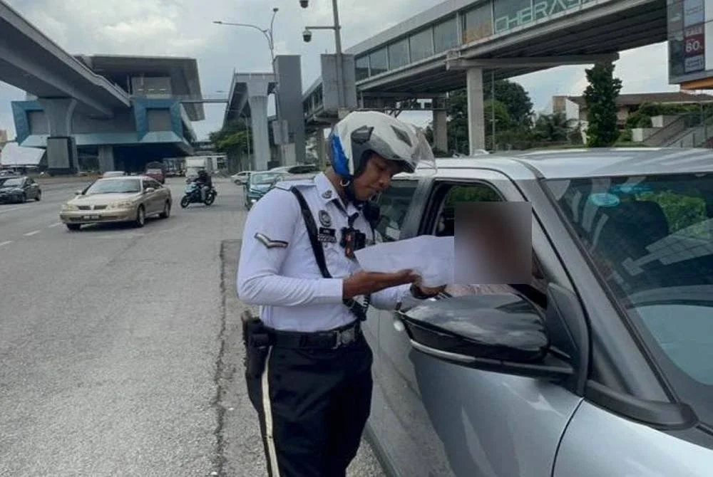 Anggota polis trafik melakukan pemeriksaan ketika kempen advokasi OP PUU.