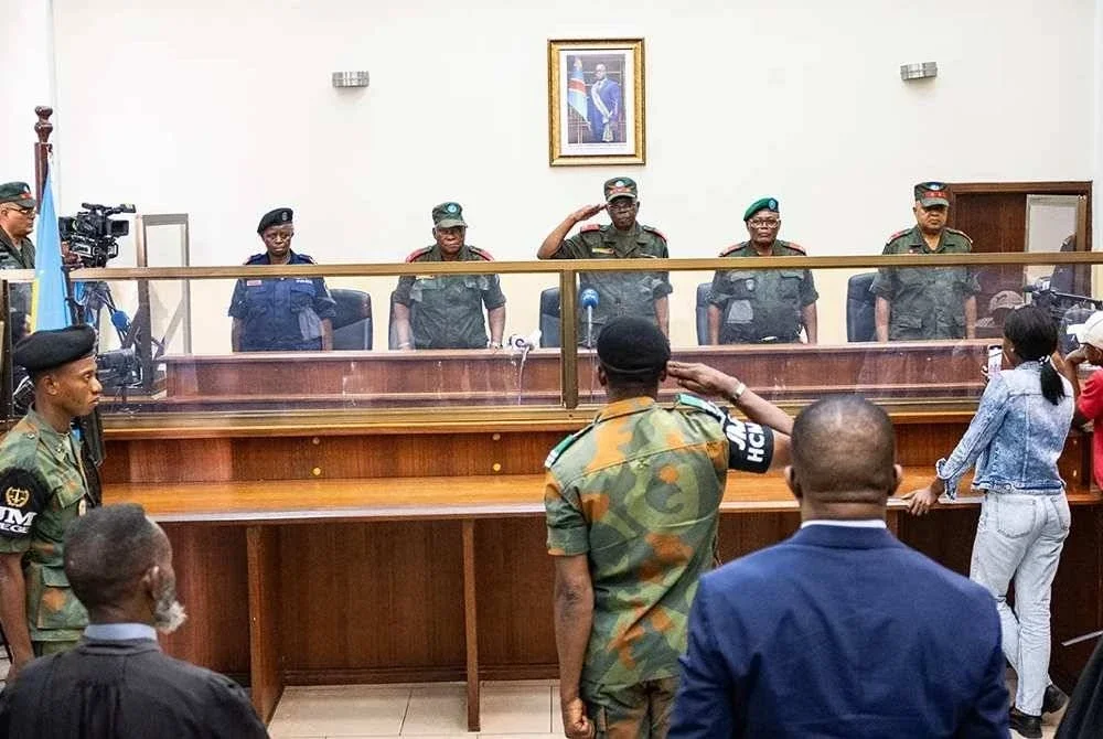 Pegawai tentera berdiri di kandang tertuduh semasa perbicaraan bekas Presiden Congo, Joseph Kabila di Kinshasa. - Foto Reuters