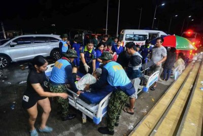 Polis membantu penduduk yang cedera semasa mereka dibawa ke hospital di Bandar Bogo, wilayah Cebu selepas gempa bumi kuat berukuran 6.9 magnitud menggoncang Filipina tengah. Foto AFP