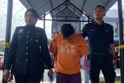 Suspek (tengah) direman bagi membantu siasatan.