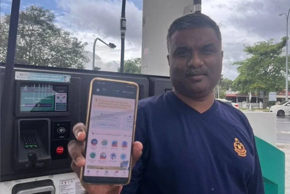 Pathmanathan menggunakan aplikasi Setel untuk pengisian petrol dengan mudah.
