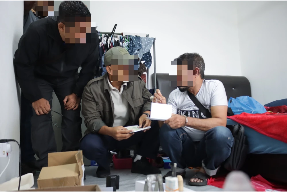 Pegawai JIM menjalankan pemeriksaan terhadap warga asing untuk siasatan kes pemalsuan pasport. FOTO: JIM