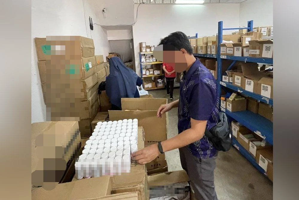 Pegawai penguat kuasa CPF Pahang melakukan pemeriksaan ke atas produk tidak berdaftar termasuk kosmetik dianggarkan bernilai RM 1.5 juta yang ditemui di dua premis di sini Selasa lalu. Foto JKNP
