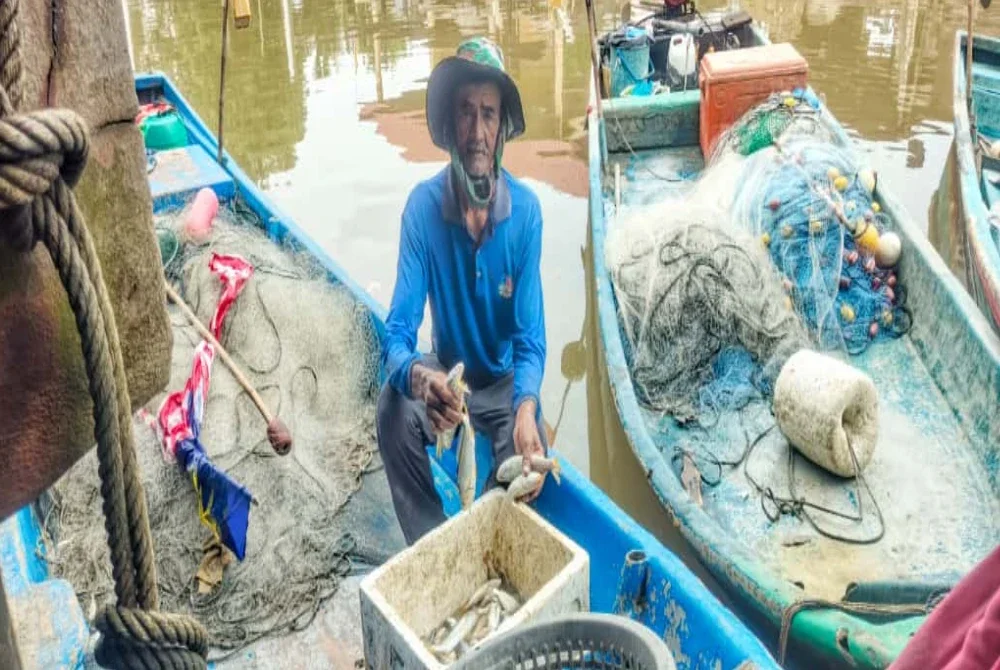 Ismail menunjukkan hasil tangkapan ikan semasa ditemui di pelantar Kampung Seberang Kota, Kuala Kedah pada Khamis.