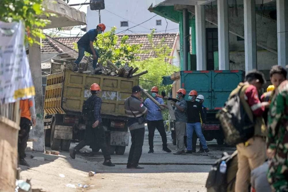 Pasukan penyelamat memindahkan sisa runtuhan ke atas trak di kawasan yang telah dikawal di Sekolah Berasrama Islam Al Khoziny di Sidoarjo, Jawa Timur. Foto AFP