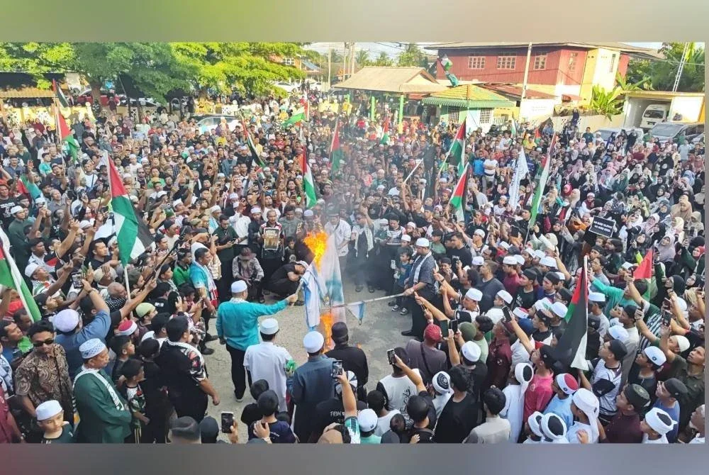 Peserta Himpunan & Flashmob Solidariti Sumud Flotilla di hadapan Masjid Rusila, Marang membakar bendera Israel bagi menyatakan bantahan terhadap penahanan aktivis kemanusiaan yang menyertai misi GSF pada Khamis. Foto Krew MarangTV
